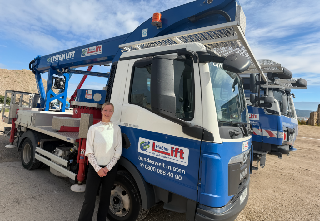 Frau steht vor einer LKW-Arbeitsbühne